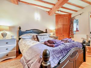 1 dormitorio con 1 cama con edredón morado en 2 Bed in Looe TRERO en Menheniot