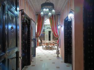 a hallway with a dining room and a chandelier at Riad Mogador in Meknès