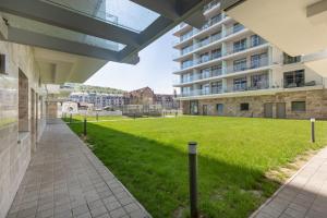 widok na trawnik z dziedzińca budynku apartamentowego w obiekcie Balticus - Piękny Apartament 200 metrów od PLAŻY Międzyzdroje by Renters w mieście Międzyzdroje