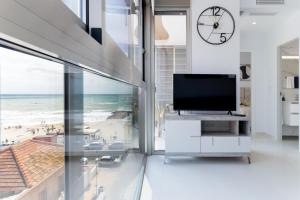 a living room with a tv and a view of the beach at Espanatour VALERIA in Torrevieja