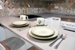 a kitchen with plates and utensils on a counter at Seaview Heaven - Otium Apartments in Santa Pola
