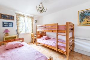1 dormitorio con 2 literas y lámpara de araña en Gite de la Maison du Gabelou, en La Barre-de-Monts