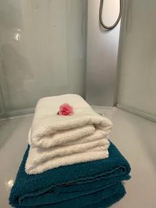 Una pila de toallas con una rosa encima. en Grindelzimmer, en Hamburgo