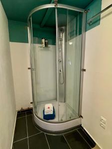 a shower with a glass door in a bathroom at Grindelzimmer in Hamburg