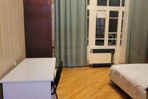 een kamer met een bed, een bureau en een raam bij Victoria apartment In Tbilisi in Tbilisi City