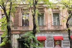 een gebouw met bomen ervoor bij Victoria apartment In Tbilisi in Tbilisi City