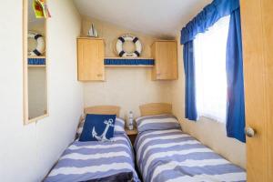 two beds in a small room in a caravan at Spacious 8 Berth Caravan At Heacham Beach Holiday Park In Norfolk Ref 21027b in Heacham