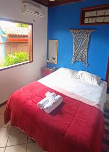 a bedroom with a bed with two towels on it at Pousada Lira Praieira Paraty in Paraty