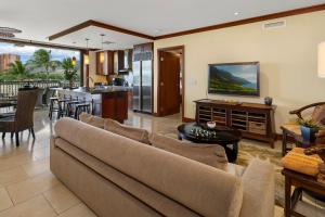a living room with a couch and a tv at Ko Olina Beach Villas O414 in Kapolei