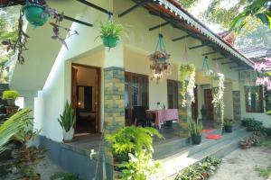 ein Haus mit einer Veranda mit einem Tisch und Topfpflanzen in der Unterkunft Marari Sophy Villa in Mararikulam
