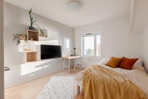 a white bedroom with a bed and a desk at Studio apartment in lake views in Tampere