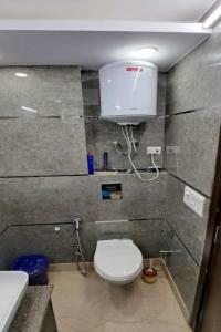 a small bathroom with a toilet and a sink at Greenleaf Apartment and Suites, Chittaranjan Park in New Delhi