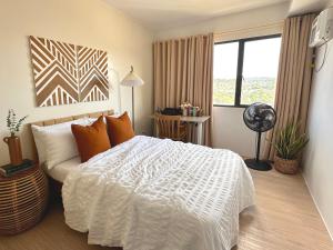 1 dormitorio con cama blanca y ventana en 1618D at The Hive Residences, en Taytay