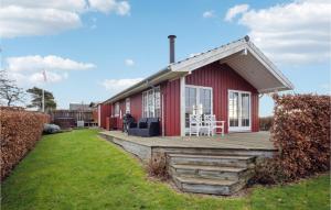 une maison rouge avec une terrasse et des chaises dans l'établissement Awesome Home In Fredericia With Kitchen, à Fredericia