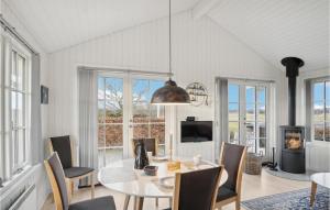 a dining room with a table and chairs and a tv at Awesome Home In Fredericia With Kitchen in Fredericia