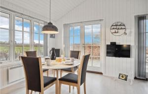 a dining room with a table and chairs and windows at Awesome Home In Fredericia With Kitchen in Fredericia