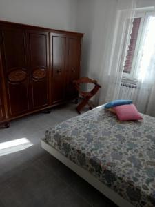 a bedroom with a bed and a dresser and a chair at Ca' LUCIANO in Castelnuovo Magra