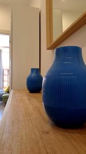 dois vasos azuis em cima de uma mesa de madeira em Le Case di Ale em Salerno