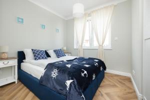a bedroom with a bed with a blue comforter at Klifowa Resort with SPA, Fitness & Kids Club by Noclegi Renters in Rewal