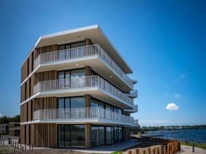 an apartment building with balconies and the water at Spacious waterfront apartment in Arnemuiden