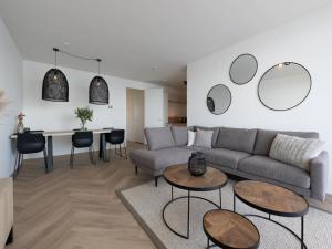 a living room with a couch and a table at Spacious waterfront apartment in Arnemuiden