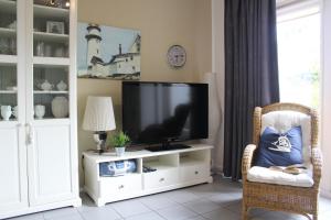 ein Wohnzimmer mit einem TV in einem weißen Unterhaltungszentrum in der Unterkunft Kustverhuur, Vakantiepark Fort Soleil 45 in Breskens