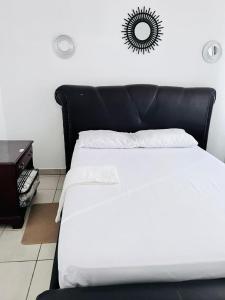 a bed with a black headboard in a room at Mphatlalatsane Executive BnB in Maseru