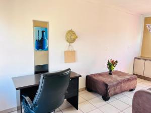 a office with a desk and a chair and a table at Mphatlalatsane Executive BnB in Maseru