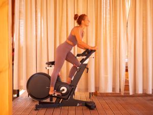a woman riding on a exercise bike on a treadmill at La Brisa Boutique Hotel in Dhërmi