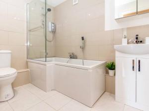a bathroom with a tub and a sink and a toilet at Mandarin Court Boutique City Centre Apartment in Worcester +11 photos