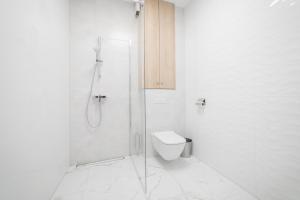 a white bathroom with a shower and a toilet at VacationClub - Zdrojowa 7 Apartament 4 in Duszniki Zdrój