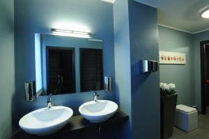 a blue bathroom with two sinks and a mirror at Park Hotel Sporting in Teramo