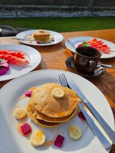 a table topped with plates of pancakes and vegetables at Pinggan Cliff in Baturaja