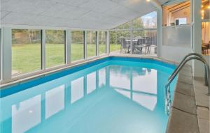 uma piscina numa casa com janelas de vidro em Amazing Home In Vggerlse With Wifi em Bøtø By