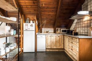 a kitchen with wooden cabinets and a white refrigerator at Era Salana by SeaMount Rentals in Unha
