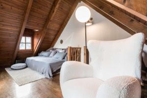 a bedroom with a bed and a chair in a attic at Era Salana by SeaMount Rentals in Unha