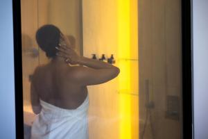 a woman brushing her hair in front of a mirror at La Brisa Boutique Hotel in Dhërmi