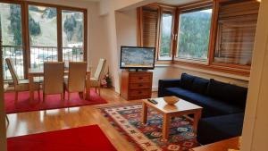 ビイェラシュニツァにあるThe Snow Crib Bjelasnica Aptのソファとテーブル、テレビのあるリビングルーム