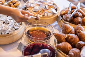 a person is pouring sauce into a bowl of food at La Brisa Boutique Hotel in Dhërmi