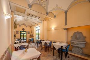 フィレンツェにあるホテル シティのテーブルと椅子が備わるレストラン