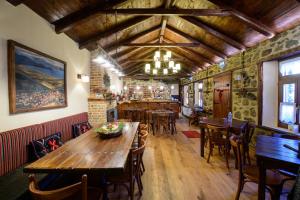 un restaurante con mesas y sillas de madera y un bar en Agios Germanos, en Agios Germanós