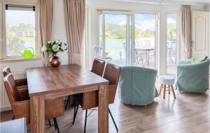 een eetkamer met een houten tafel en stoelen bij Amazing Home In Molenschot With House Sea View in Molenschot