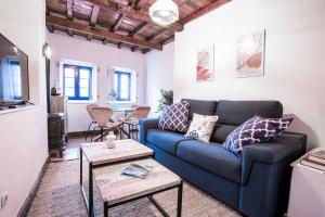 Una sala de estar con un sofá azul y una mesa. en Beautiful house at the seaside, en Cudillero