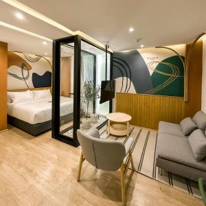 um quarto com uma cama, uma cadeira e um espelho em Double B Hostel em Banguecoque