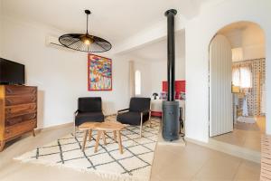 a living room with two chairs and a table and a stove at Villa Beldi in Essaouira