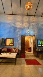 uma sala de estar com um sofá e uma parede azul em DAR LALLA Aicha 2 em Rabat