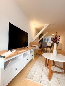 una sala de estar con una gran TV de pantalla plana en una cómoda en Mulhouse En Douceur, Hypercentre de Mulhouse, en Mulhouse