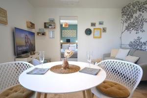 una mesa blanca y sillas en la sala de estar. en L'Emoustillant jacuzzi, unique et hors du temps, en La Richardais