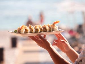 a person holding up a plate of food at La Brisa Boutique Hotel in Dhërmi