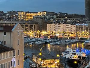 ein Hafen mit Booten in einer Stadt in der Nacht in der Unterkunft Loft moderne vue Vieux Port Terrasse Rooftop in Marseille